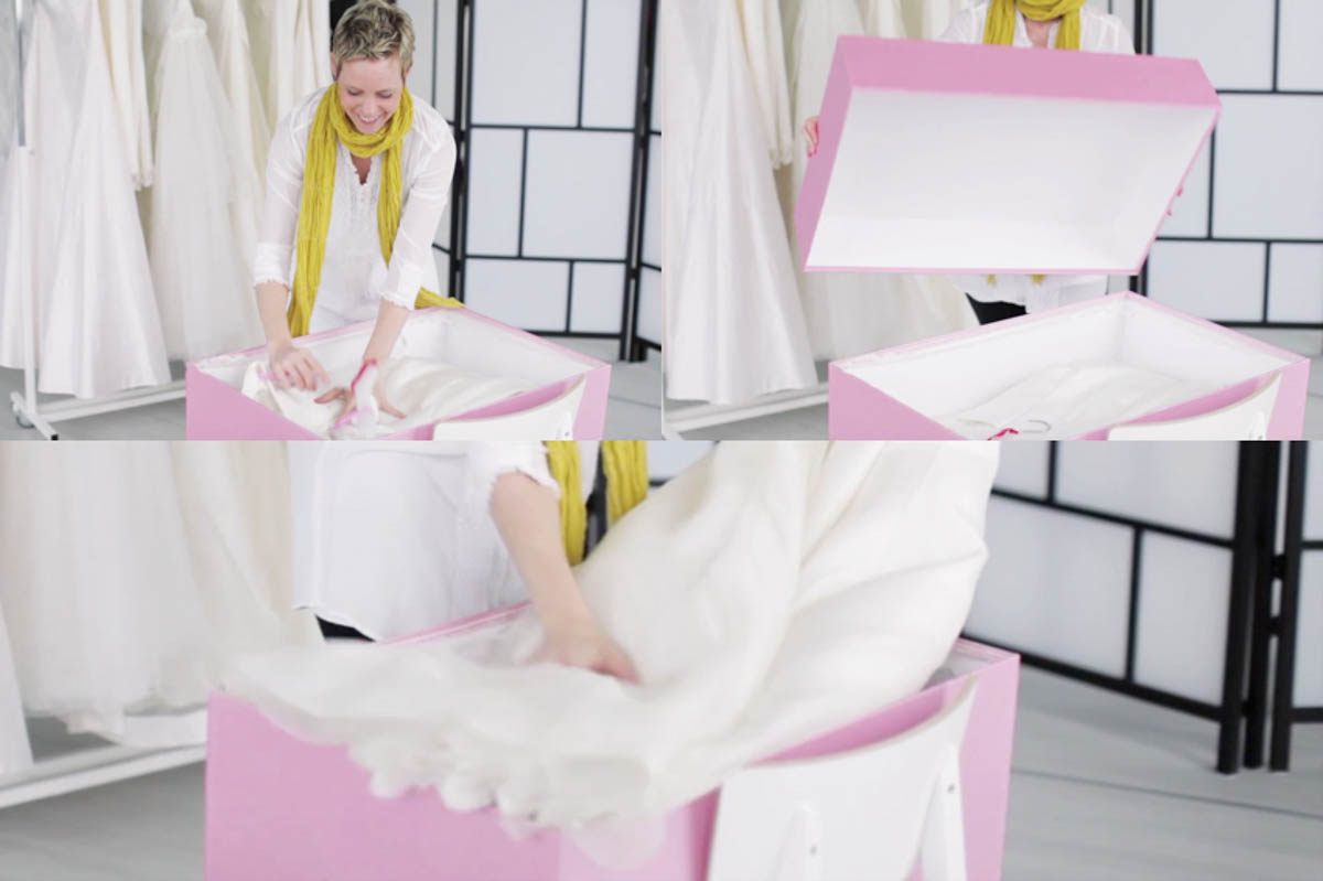 Braut legt ihr Brautkleid in eine rosa Brautkleidbox