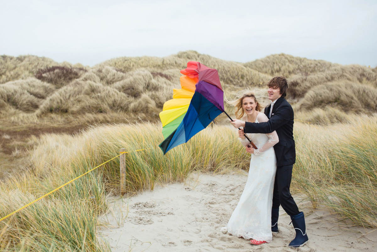 Brautpaar mit Regenschirm in den Dünen beim After-Wedding-Shooting am Strand