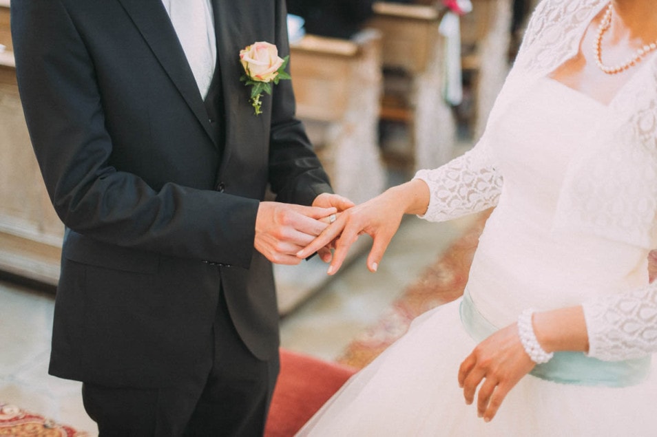 Bräutigam steckt Ring an Finger der Braut