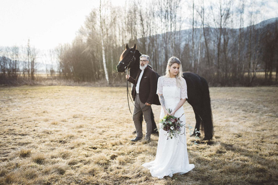 Boho Braut im Hintergrund Bräutigam mit Pferd
