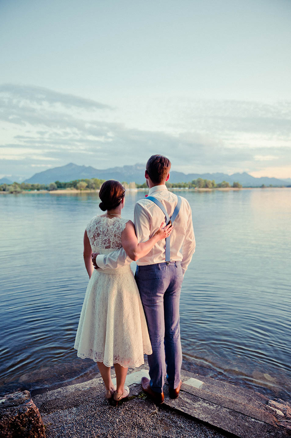 Hochzeitsparty am See, Brautpaar Portraitbild als es auf den See blickt