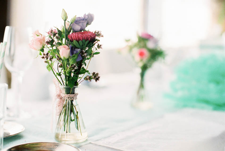 Sommerblumen in kleinen Vasen als Tischschmucke bei Hochzeit