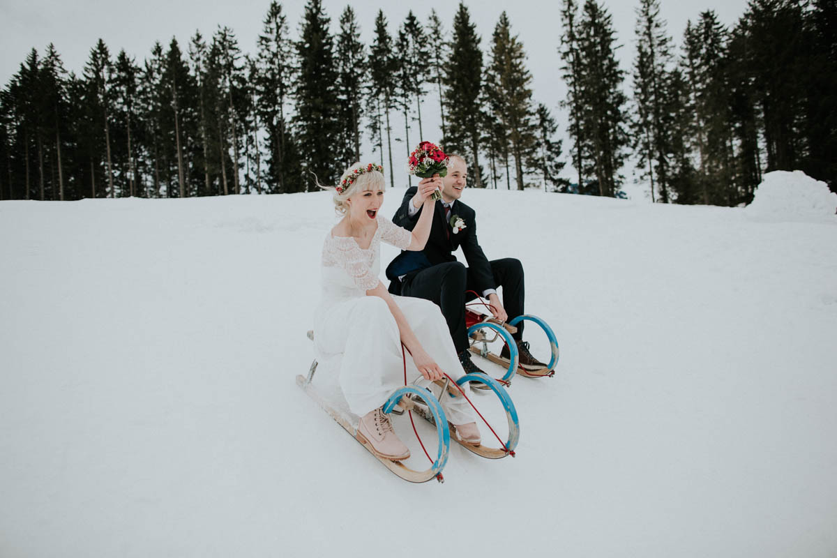 Brautpaar fährt Schlitten bei der Hochzeit im Schnee