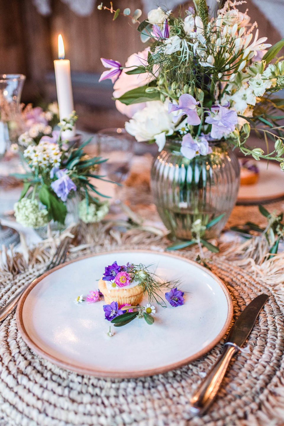 Blumen und kleines Törtchen auf Paletten-Tisch