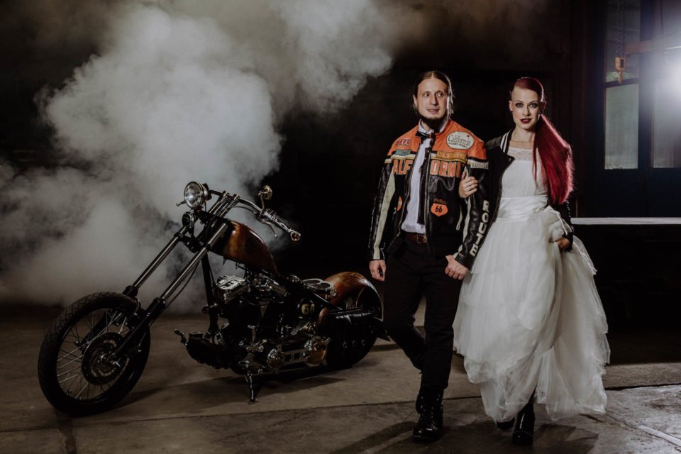 Biker Brautpaar mit Harley im Hintergrund