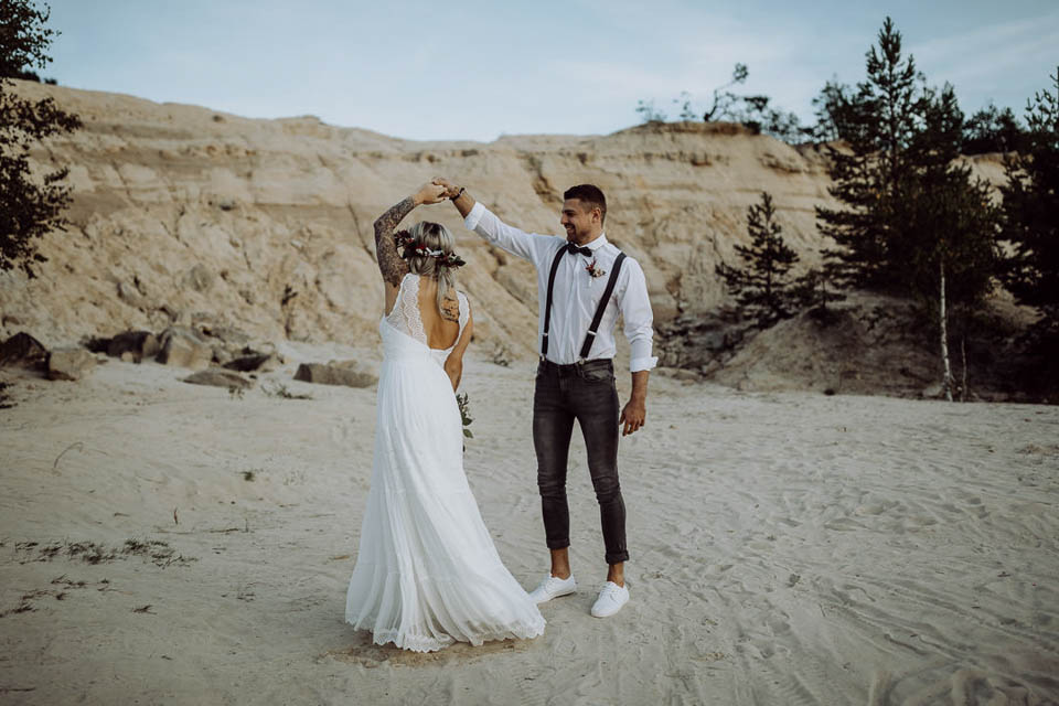Tanzendes Boho Brautpaar im Sand