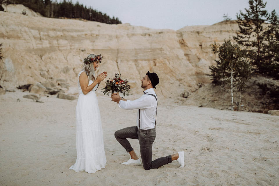 Bräutigam macht Braut Antrag im Sand