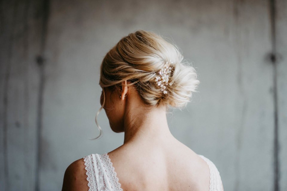 blonde Braut mit Steckfrisur und Haarschmuck von hinten