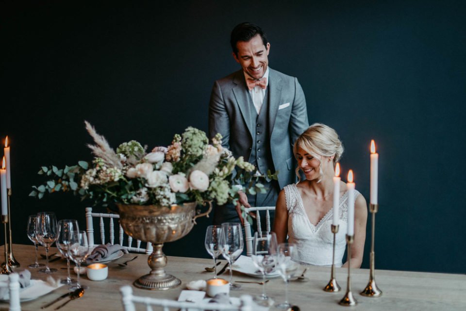 Brautpaar lächelt am Tisch der modernen Hochzeitsinspiration 