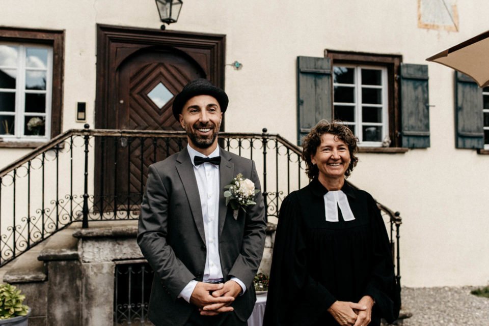Bräutigam wartet neben Pfarrerin auf seine Braut für die Hochzeit im September