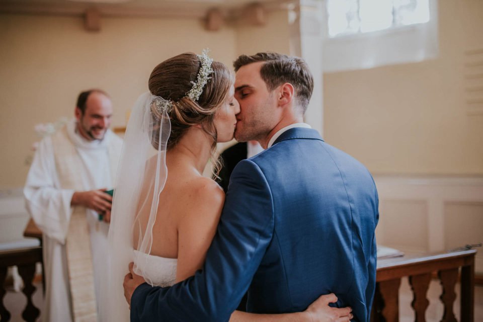 Brautpaar küsst sich nach der kirchlichen Trauung