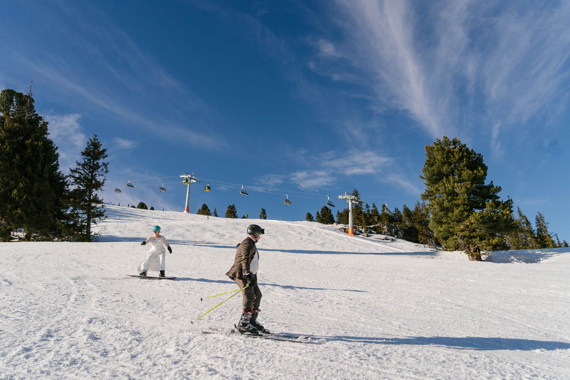 Braut auf dem Snowboard, Bräutigam auf Skiern