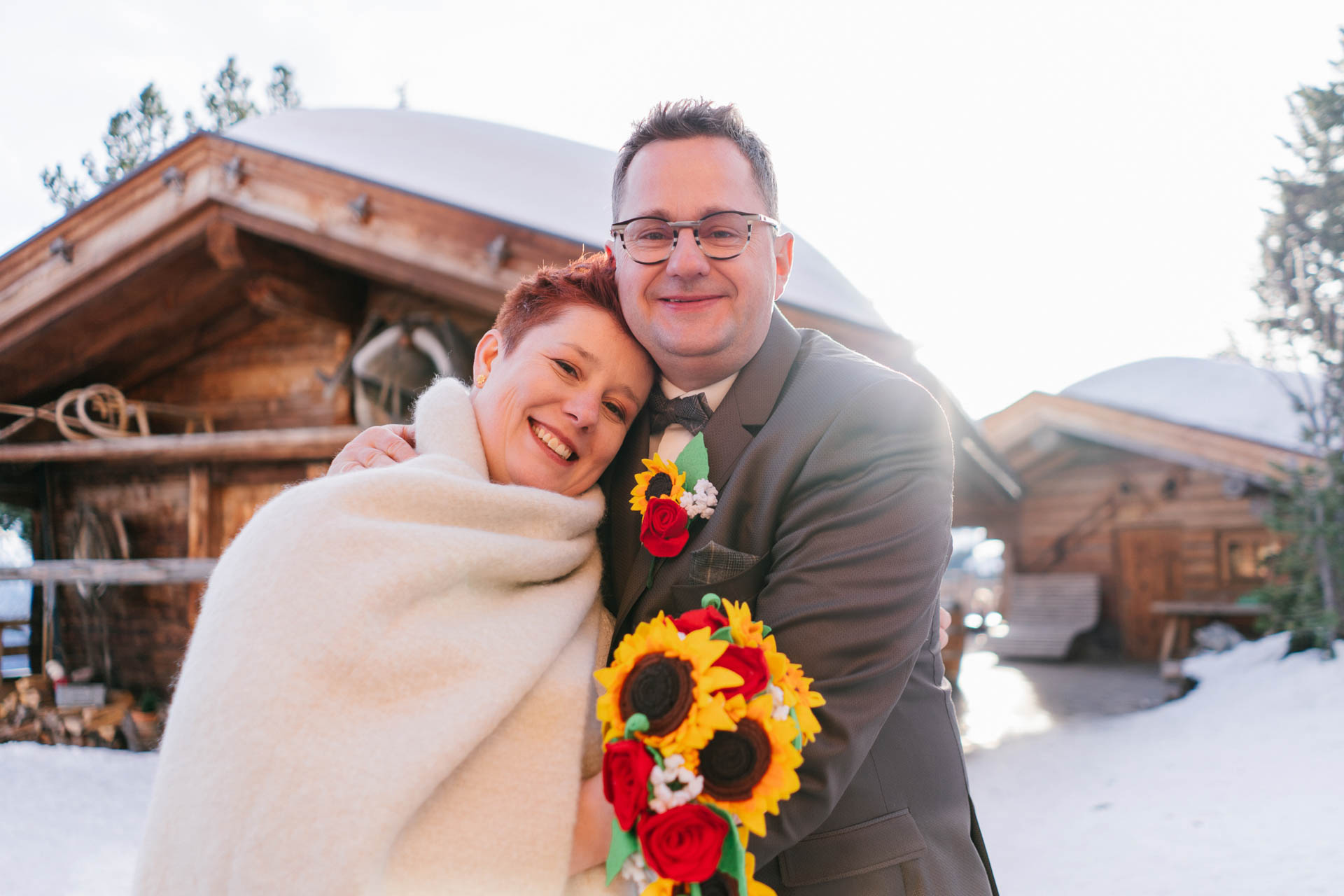 glückliches Brautpaar im Schnee bei Winterhochzeit im Zillertal