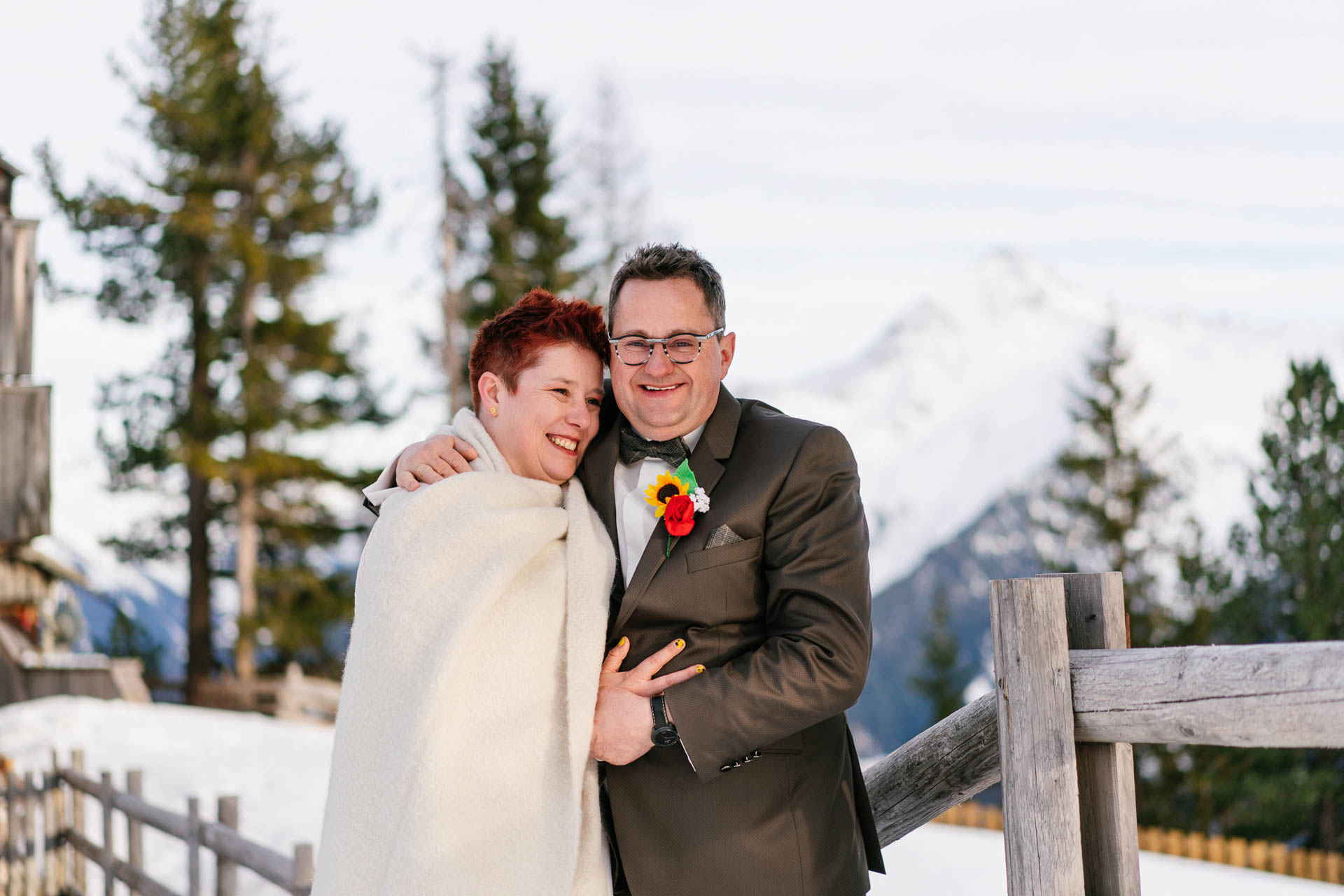 Brautpaar glücklich im Schnee bei Winterhochzeit in den Bergen