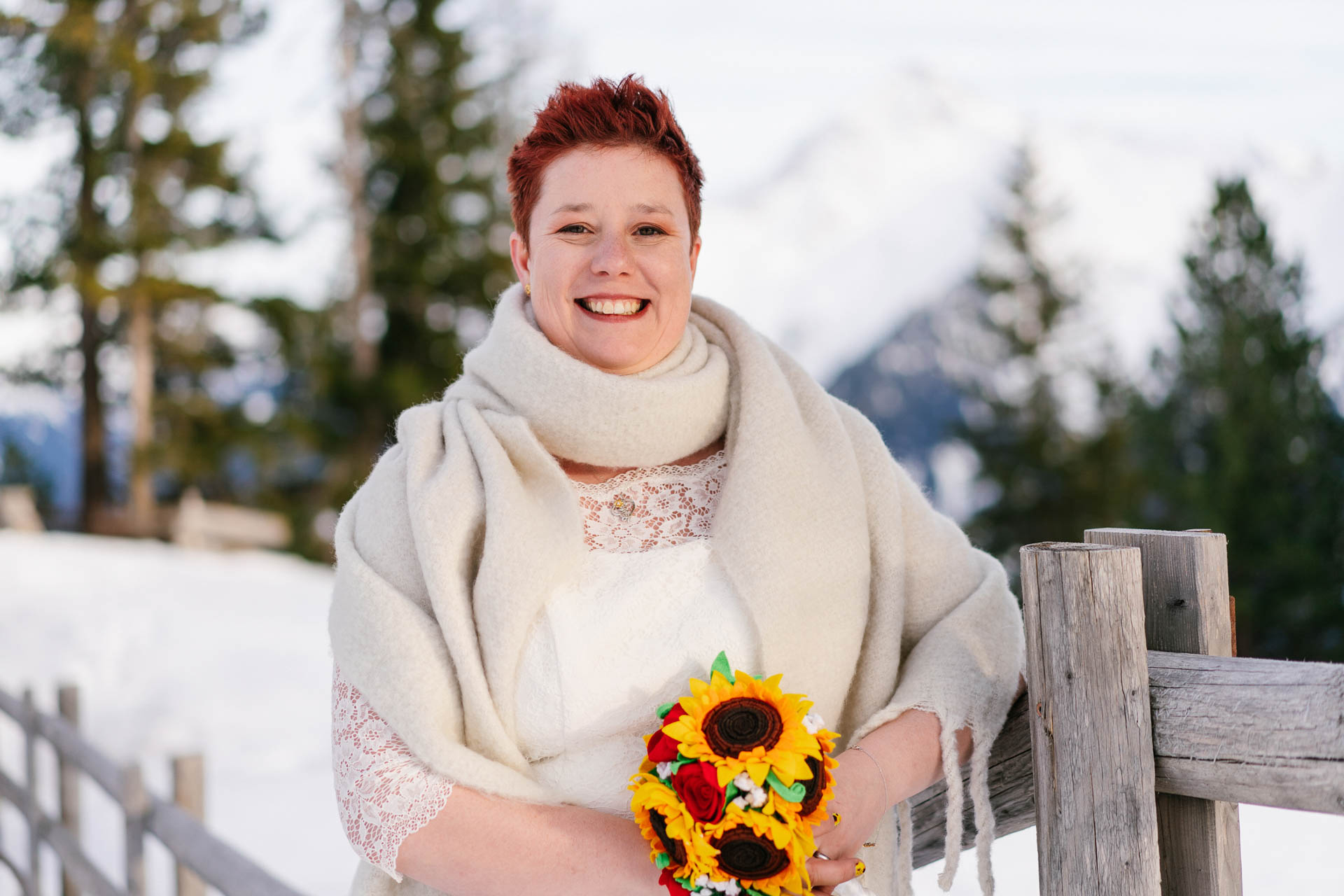 glücklich strahlende Braut mit roten, kurzen Haaren im Schnee