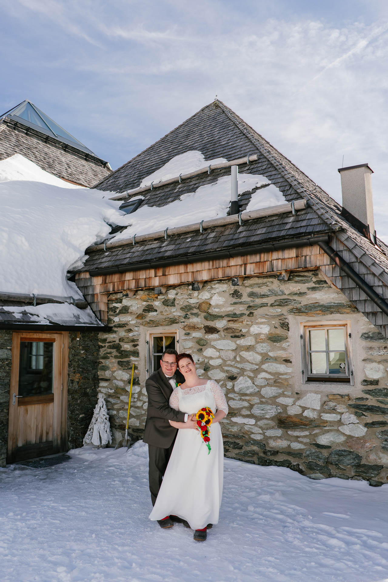 Winterhochzeit im Zillertal, Brautpaar glücklich im Schnee vor Schneekarthütte