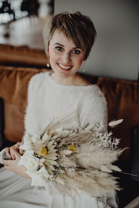 Kurzhaar-Braut mit Brautpulli und Trockenblumen