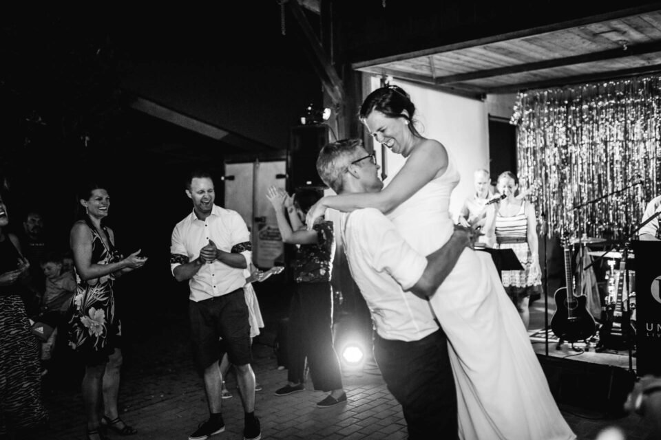 Bräutigam hält Braut auf der Tanzfläche hoch