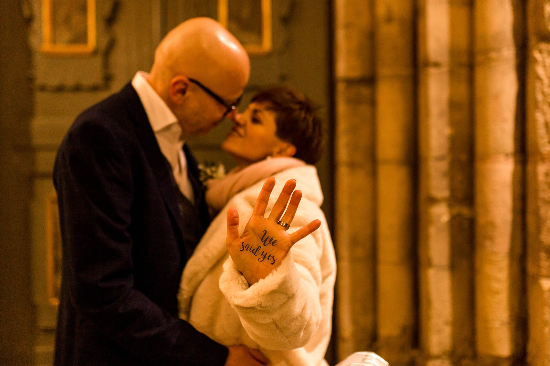 Braut im Brautmantel zeigt ihre Hand mit der Aufschrift we said yes