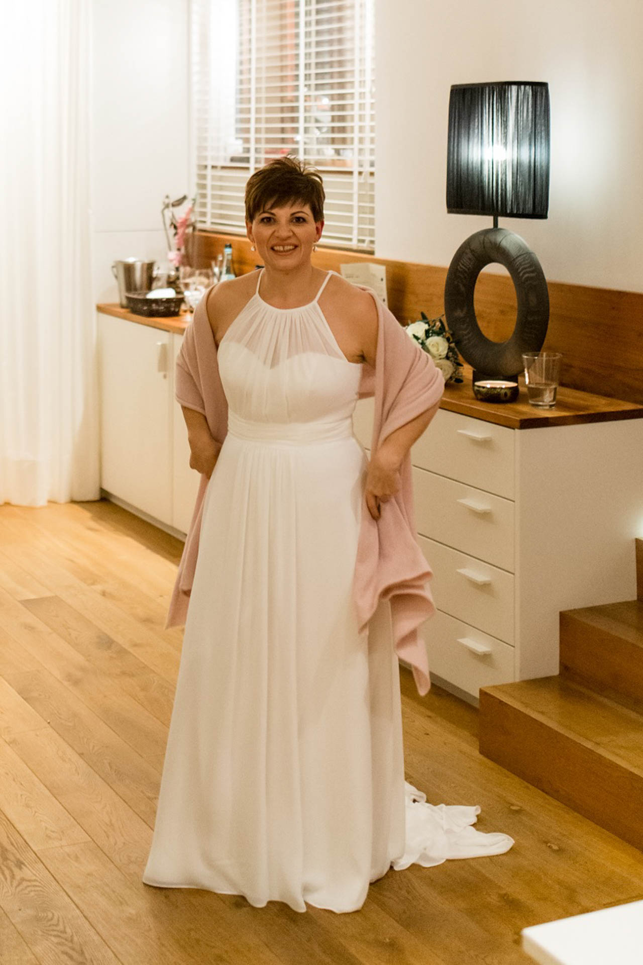 Braut im schlichten Brautkleid mit rosa Kaschmirschal über den Schultern