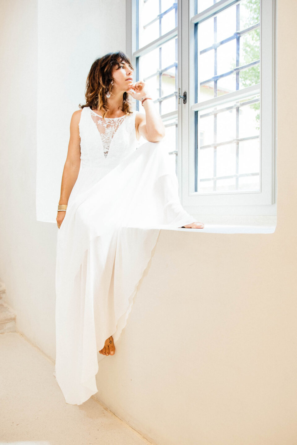 Braut sitzt ruhig am Fenster im Brautkleid KUESSdieBIBBONA – Slow Wedding heißt bewusst heiraten statt Hochzeitsstress