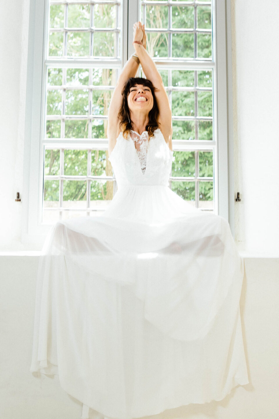 Brautkleid Bibbona mit glitzernder 3D-Spitze, Braut mit erhobenen Armen